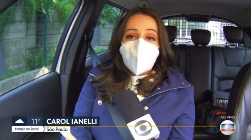 Carol Ianelli no carro de máscara segurando microfone
