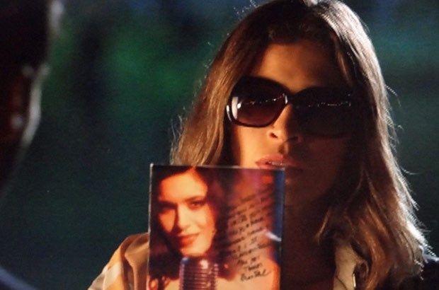De óculos escuros, Ester segura DVD com dedicatória de Cristal na direção de Cassiano 