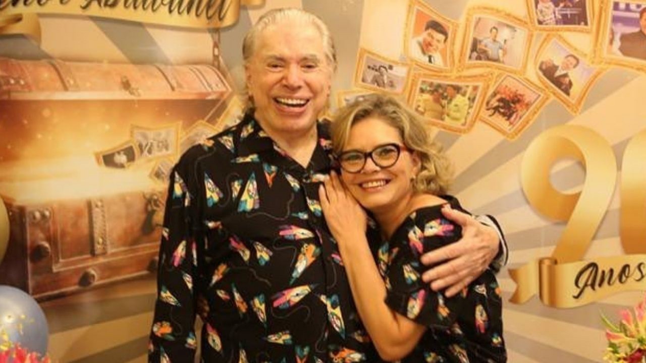 Silvio Santos e Cintia Abravanel sorrindo, de pijamas, abraçados, posando para foto