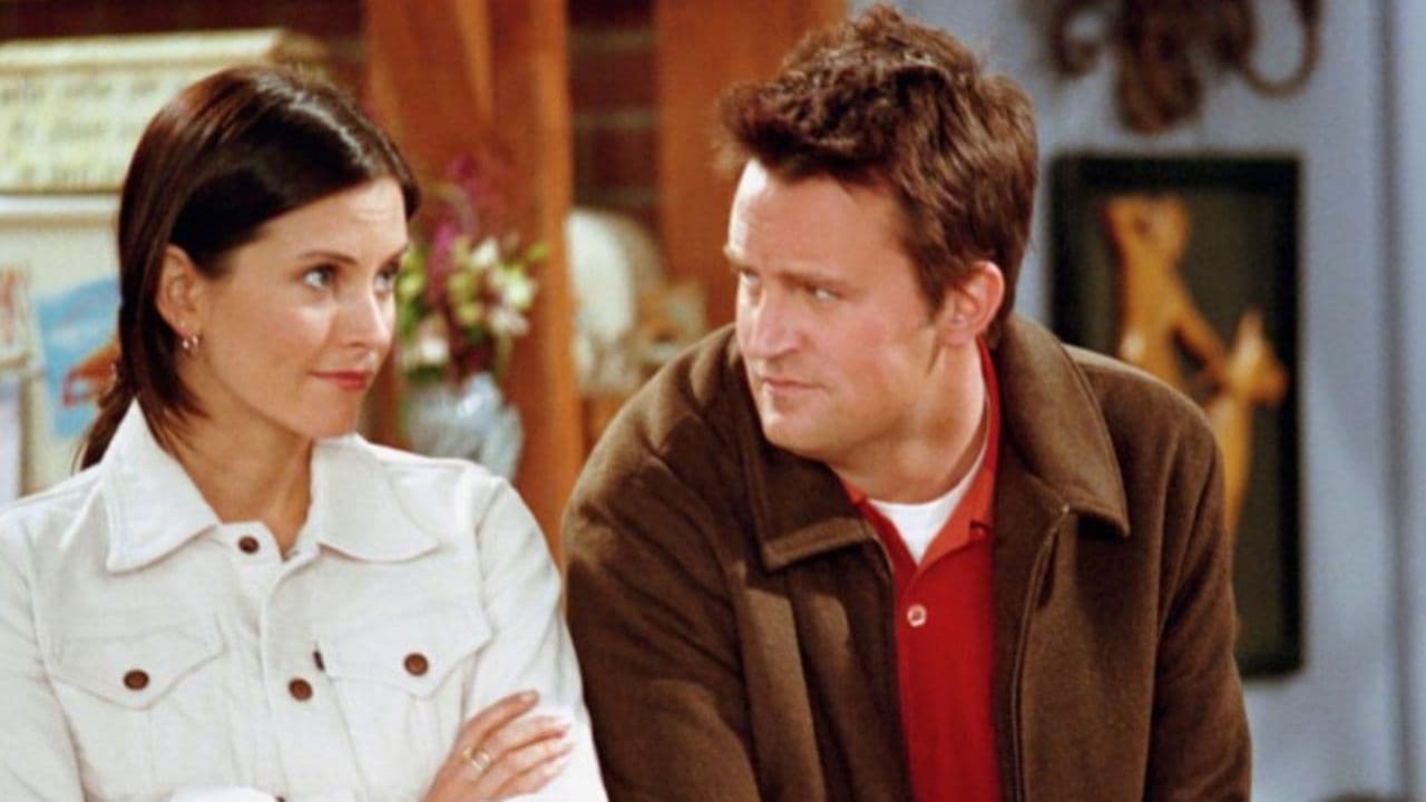 Monica e Chandler lado a lado em cena de Friends, ambos sem sorrir