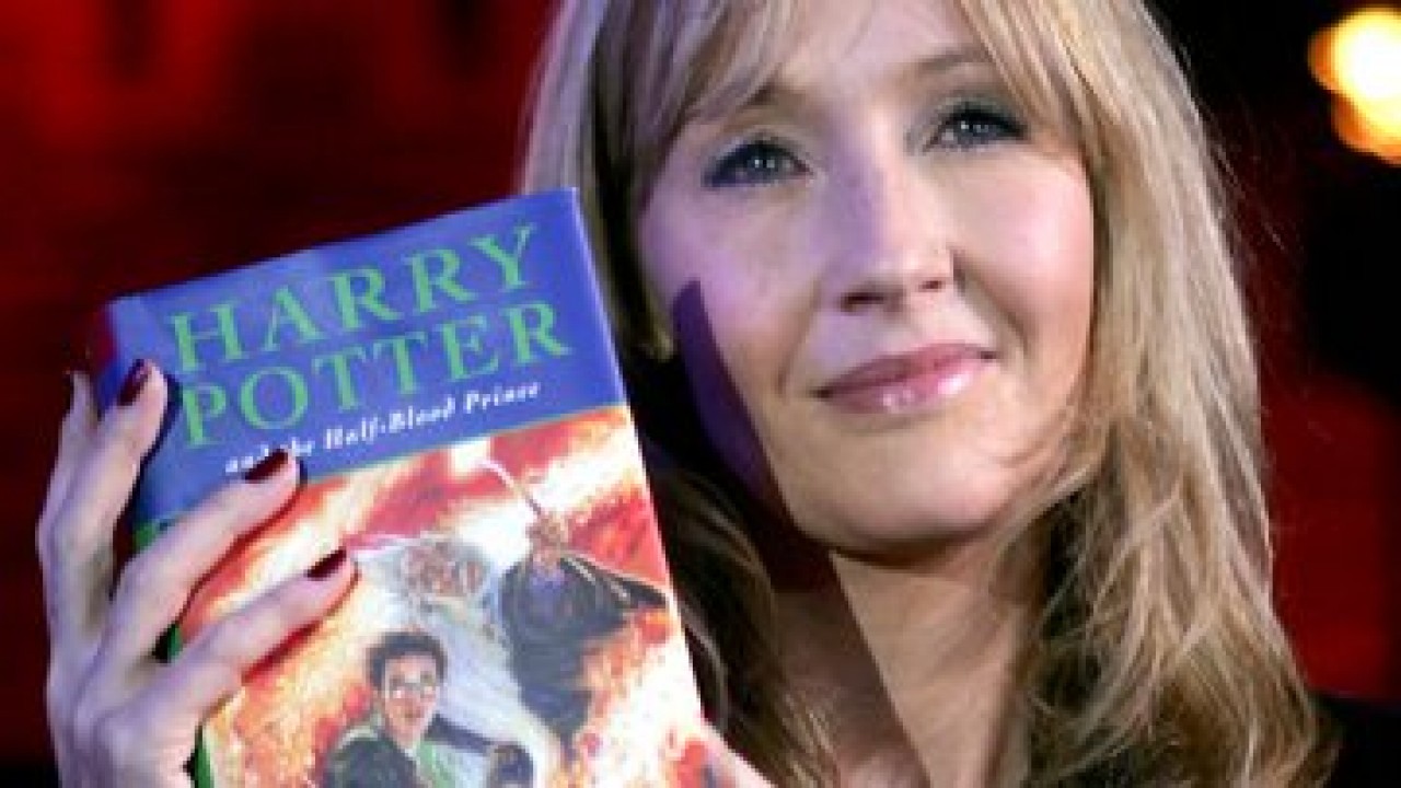 J.K. Rowling com Harry Potter na mão