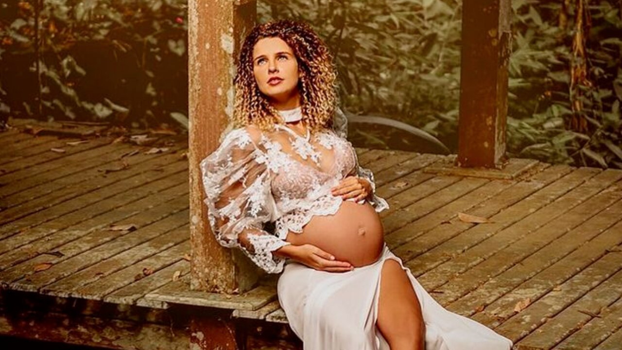 Debby Lagranha em ensaio grávida, com a mão na barriga