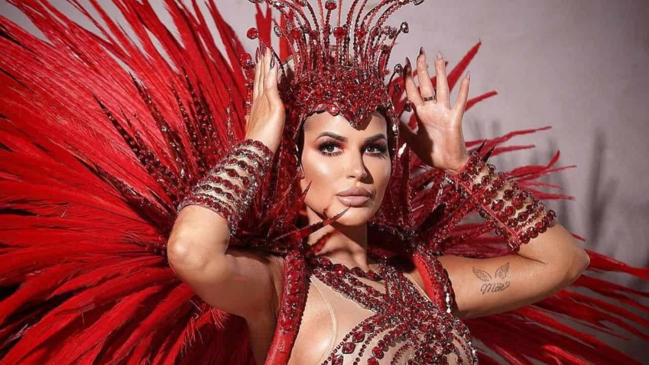 Deolane Bezerra fazendo carão, com mãos próximas da cabeça, em fantasia de Carnaval vermelha