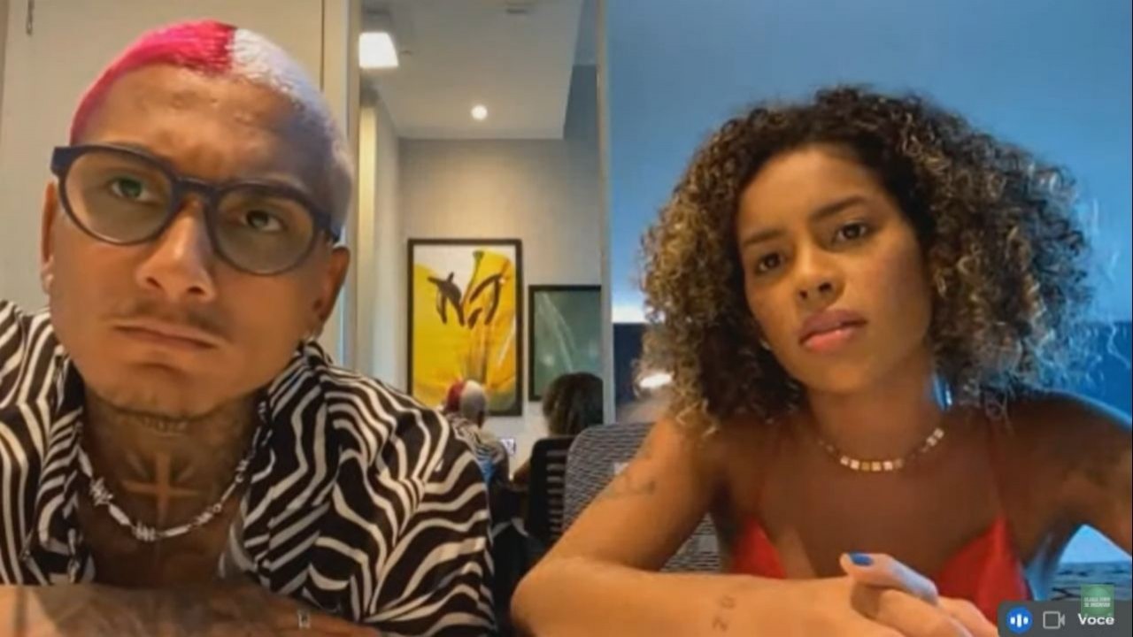 Dynho Alves de camisa com estampa de zebra e Sthe Alves de camiseta laranja olhando para a câmera