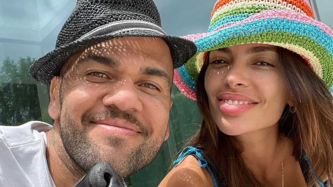Daniel Alves e a esposa, Joana Sanz, posando para foto sorrindo, com chapéus