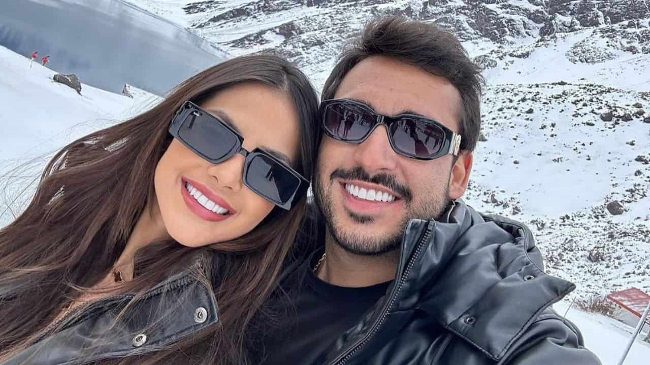 Luana Andrade e João Hadad de roupas pretas, posando para foto na neve, sorrindo