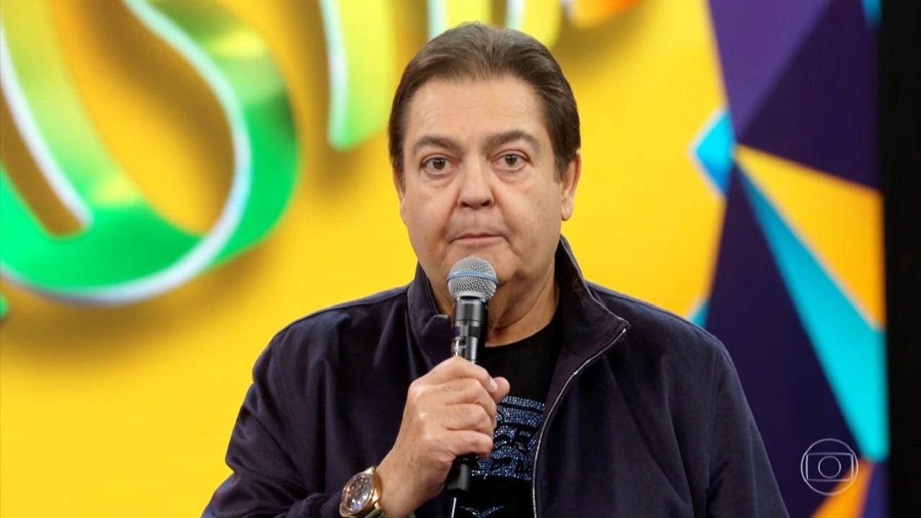 Faustão segurando o microfone durante apresentação do Domingão na Globo