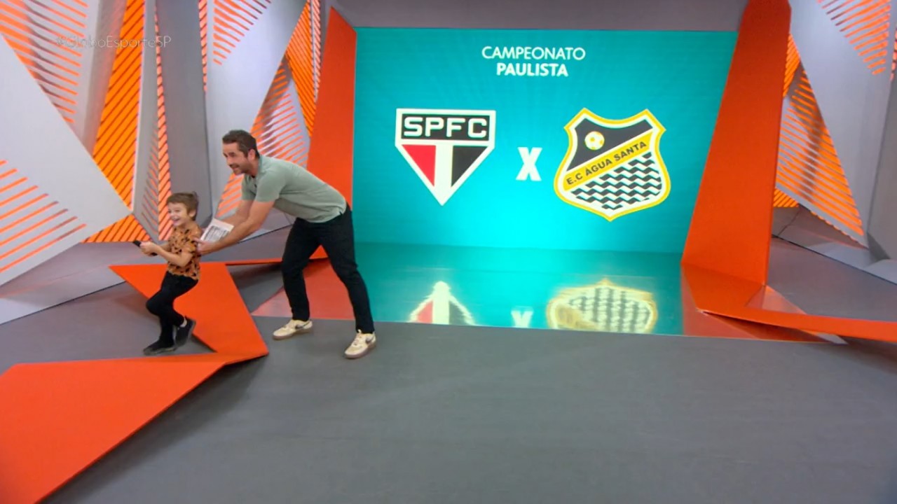Felipe Andreoli empurrando seu filho no cenário do Globo Esporte