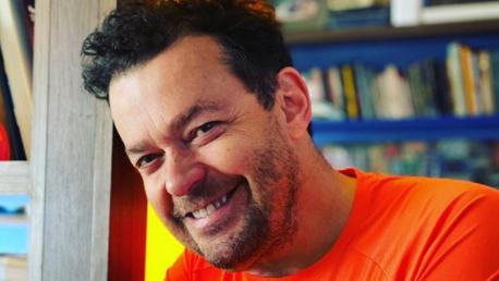 Fernando Rocha sorrindo de camiseta laranja