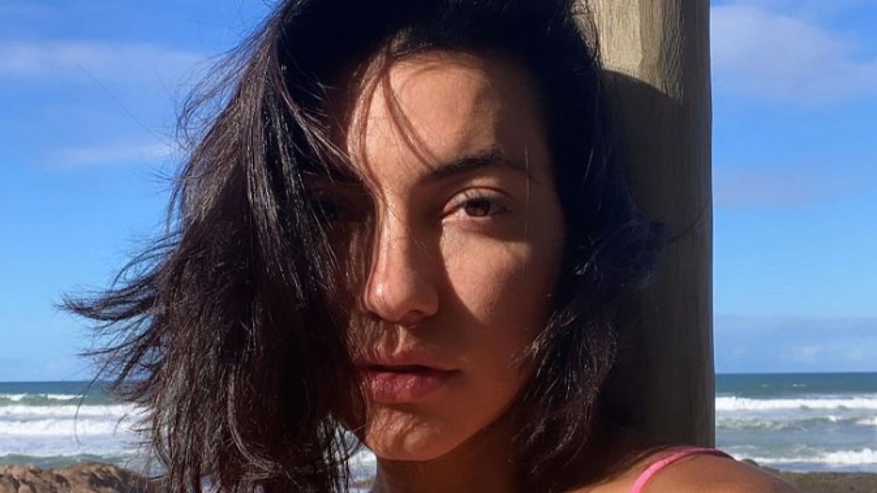 Gabi Prado na praia com cabelo na cara