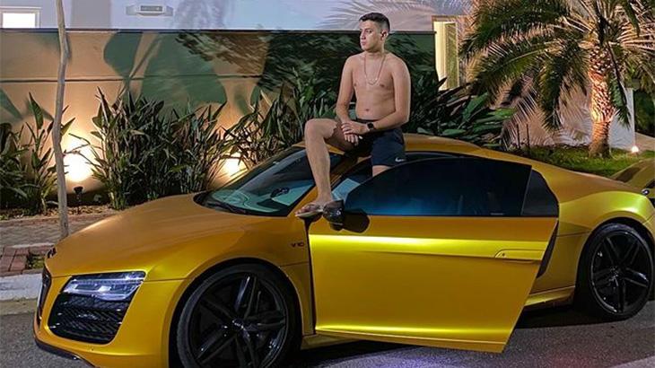 Gabriel Rodrigues em cima de um carro de luxo