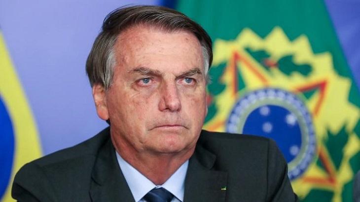 Bolsonaro sentado e com expressão de seriedade