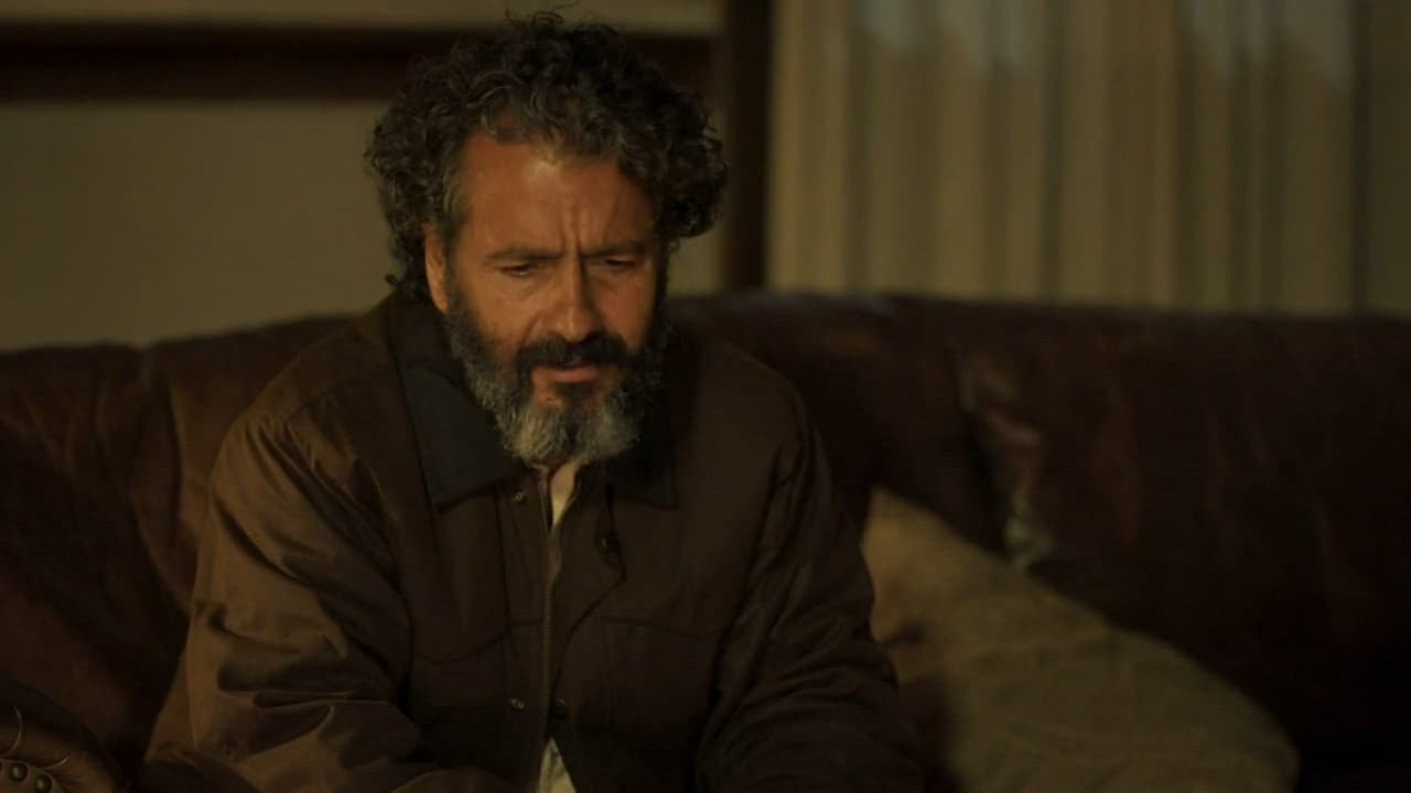 Marcos Palmeira como José Leôncio na novela Pantanal. Ele está sentado no sofá da sala da fazenda
