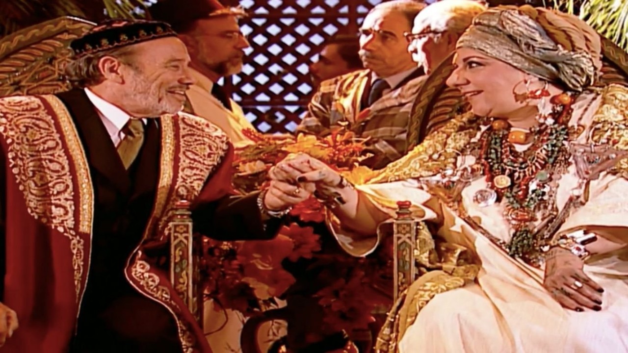 Ali e Zoraide sentados durante casamento em cena de O Clone
