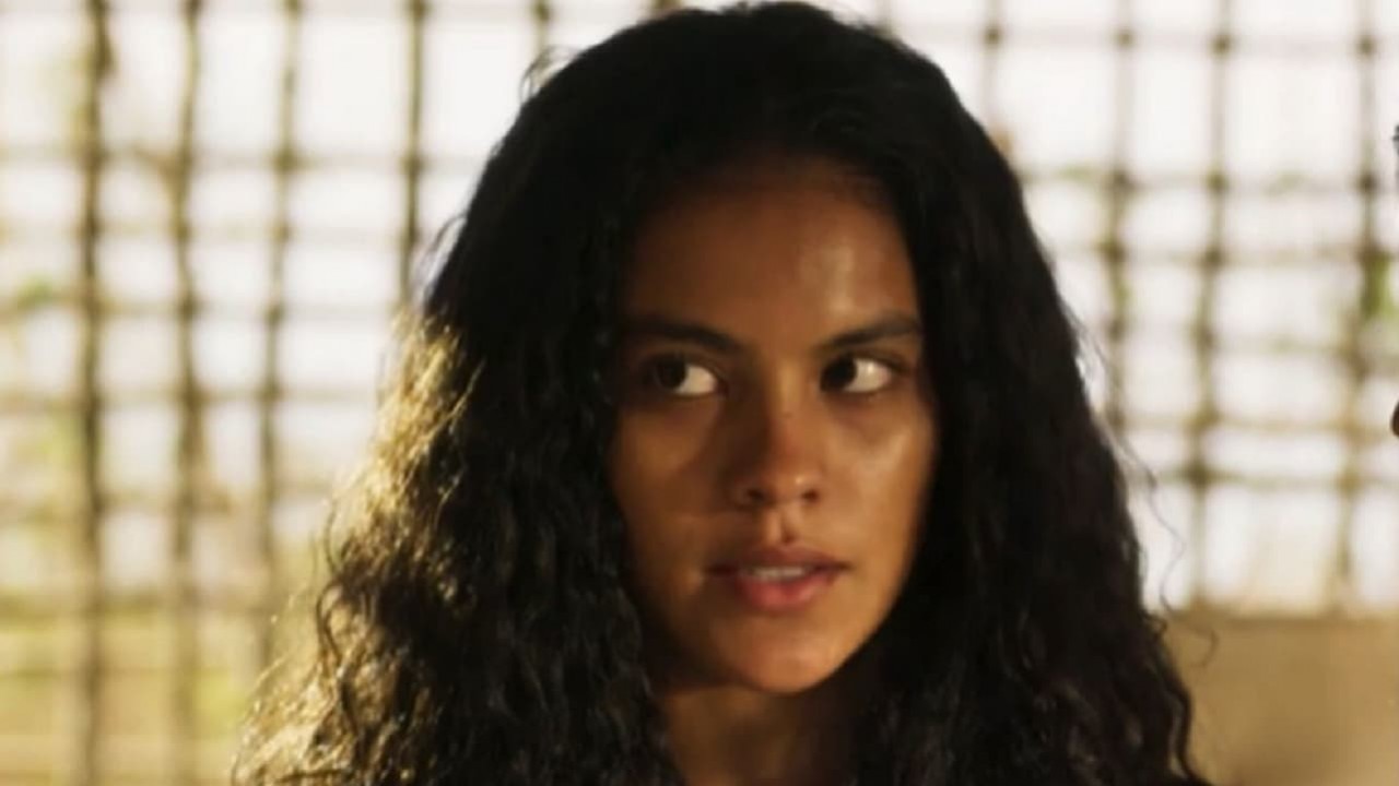 Bella Campos como Muda na novela Pantanal. Ela está em pé na fazenda de José Alfredo