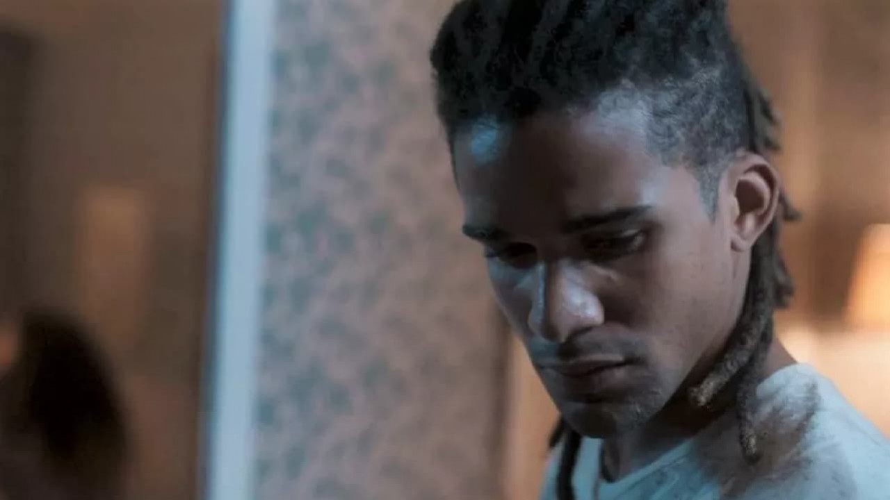Lucas Leto como Marcelo em Pantanal. Ele está atrás da porta do quarto dos pais