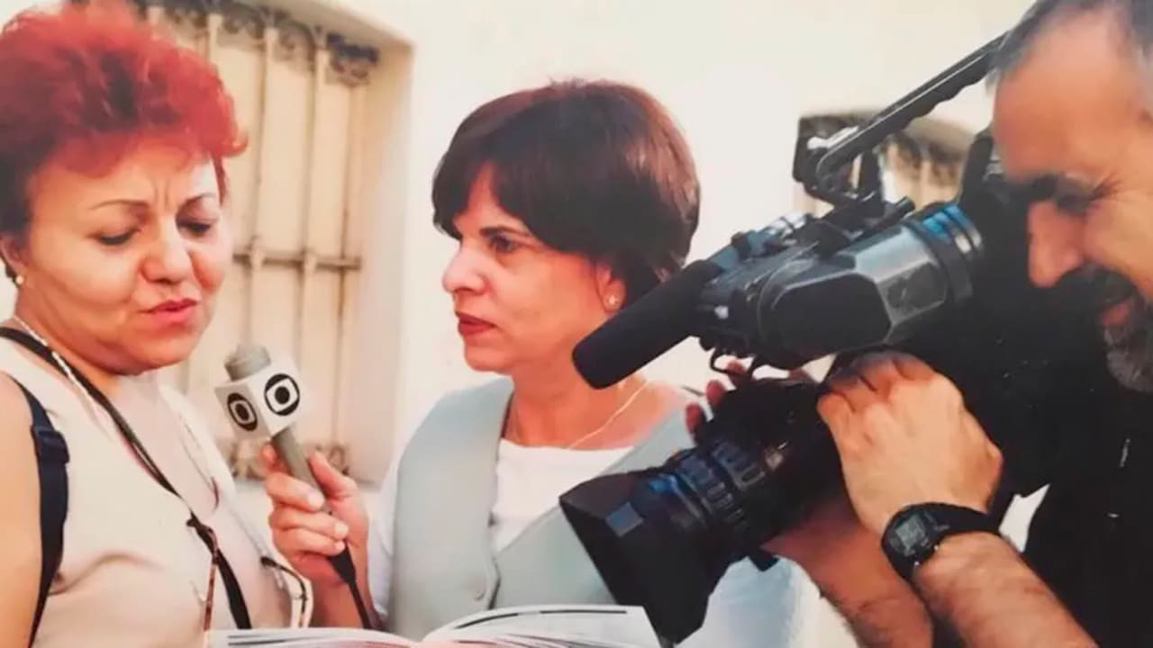 Helena de Grammont com microfone da Globo entrevistando