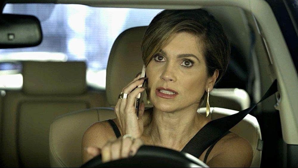 Helena dentro do carro falando ao celular 