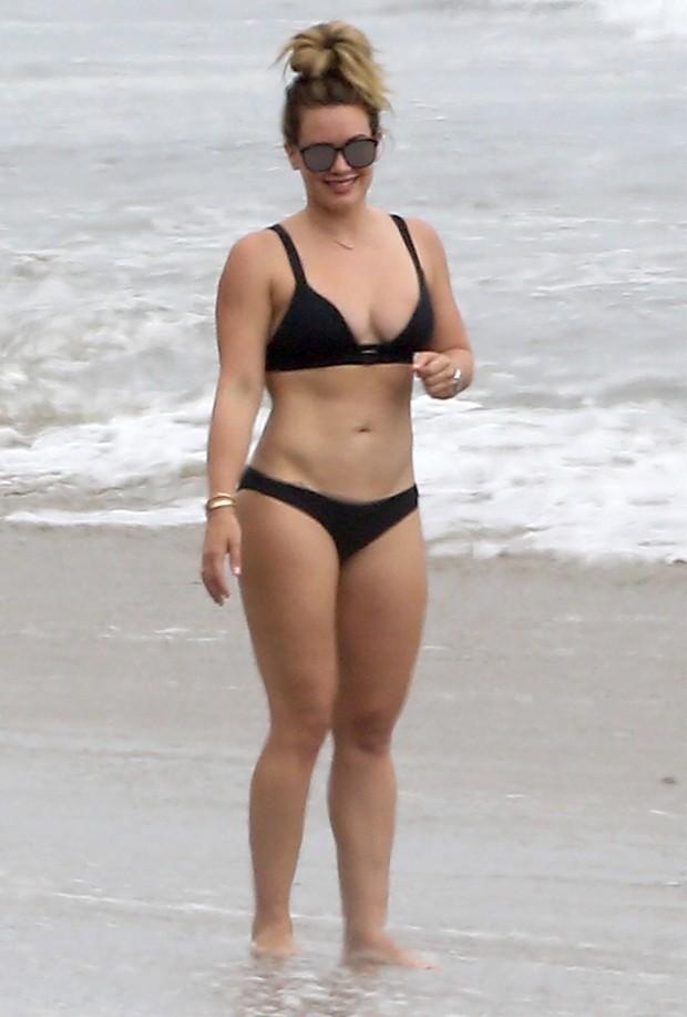 Hilary Duff impressiona pela boa forma na praia