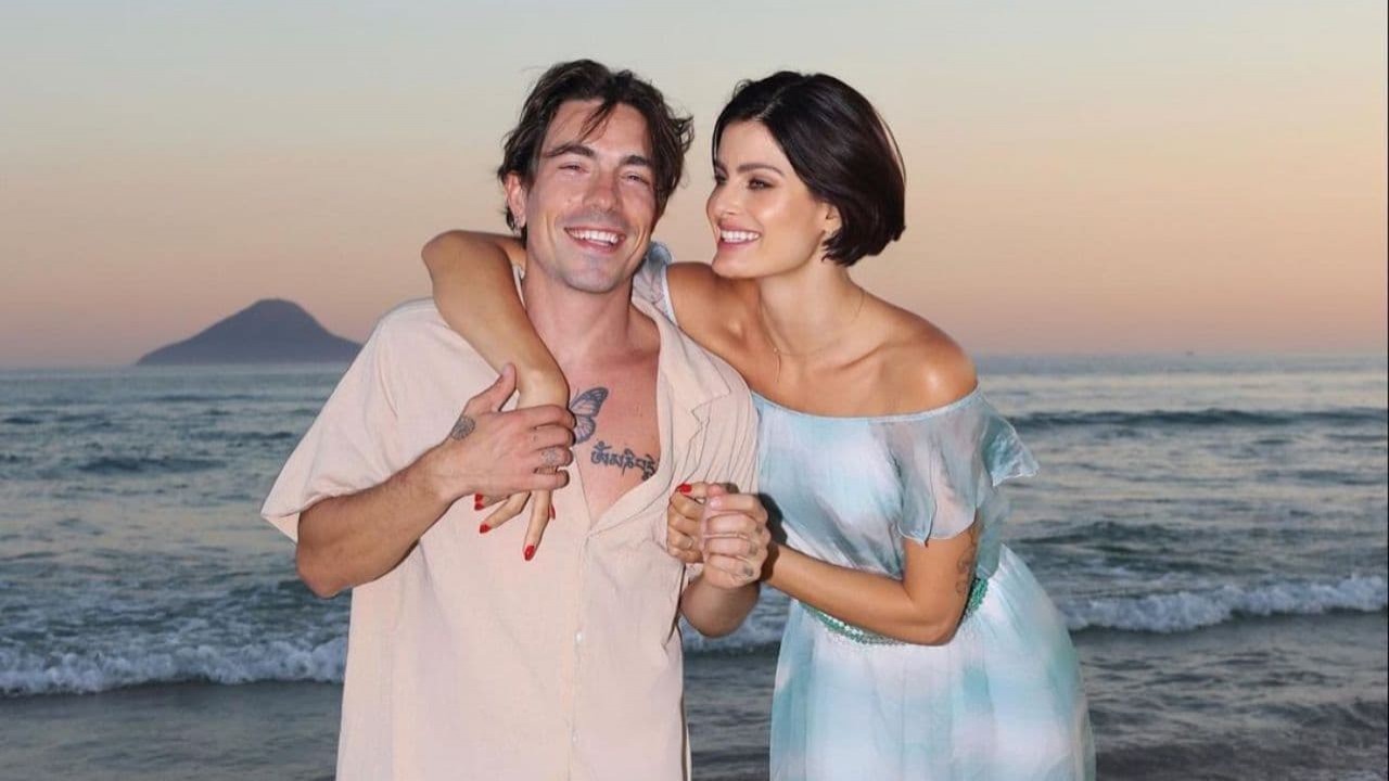 Di Ferrero e Isabeli Fontana na praia, sorrindo e abraçados