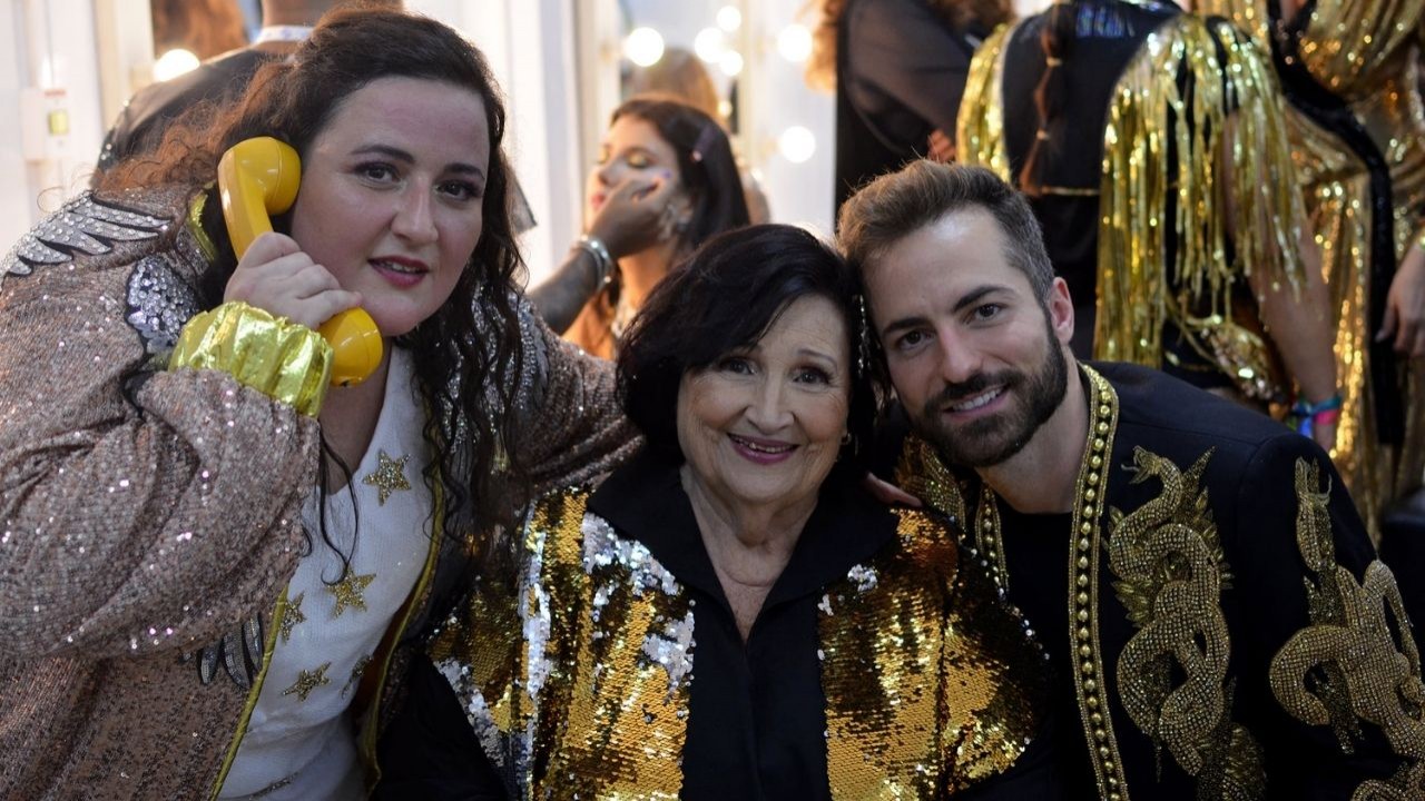 Ju Amaral, Déa Lúcia e Thales Bretas posando para foto com roupas do desfile de Carnaval da São Clemente