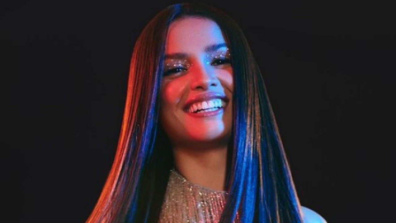 Com um fundo preto, Juliette sorri em foto de divulgação da turnê Caminho, que marca sua estreia como cantora nos palcos