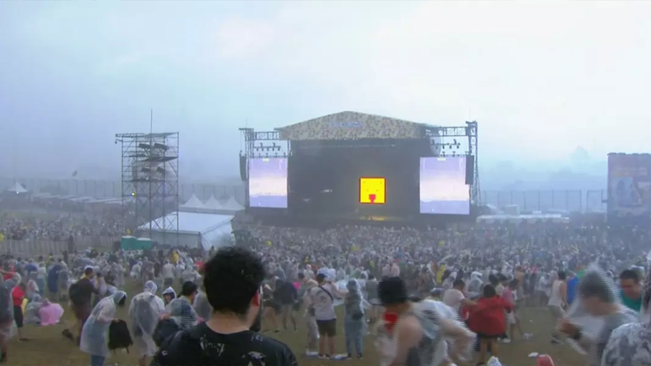 Panorâmica do evento, mostrando o palco o fundo e público em meio da tempestade