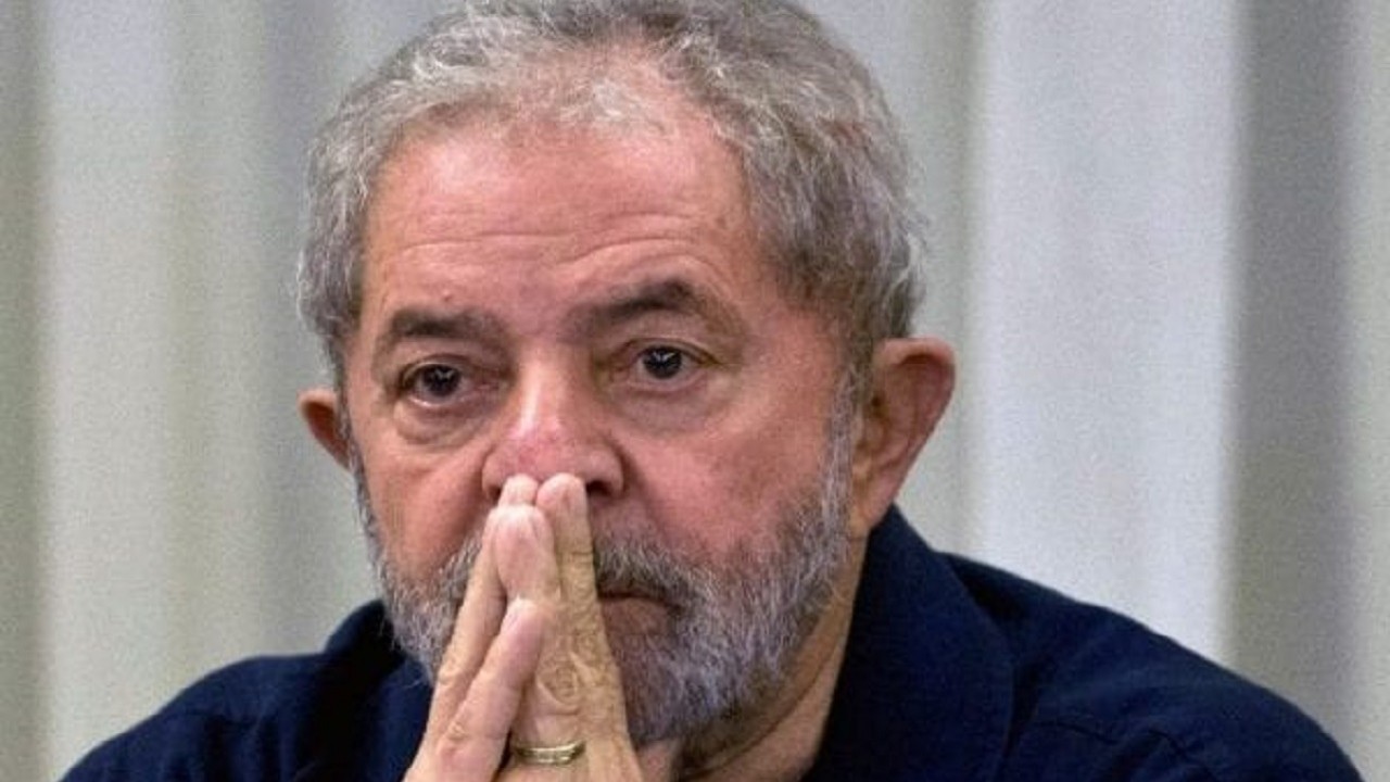 Lula sentado com a mão cruzada no rosto; ele não vai à sabatina da Jovem Pan