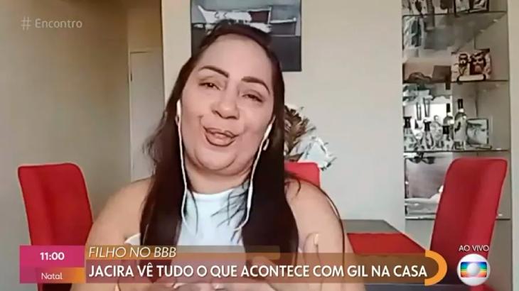 Mãe de Gilberto do BBB21 está com fone de ouvido e falando em entrevista por videoconferência para o programa "Encontro"