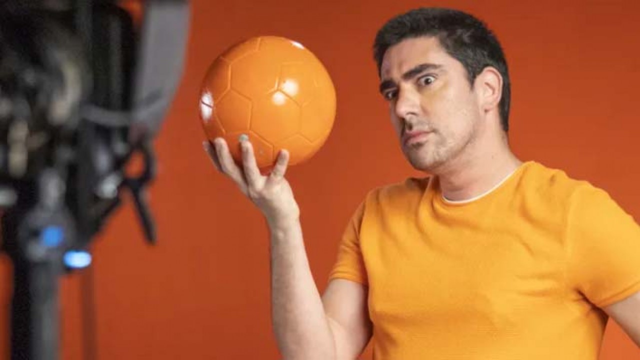 Marcelo Adnet com bola laranja na mão
