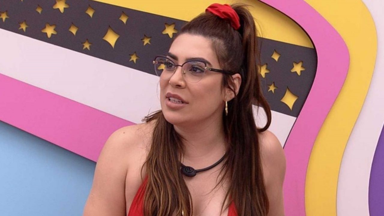 Naiara Azevedo em quarto colorido do Big Brother Brasil, de biquíni vermelho e óculos