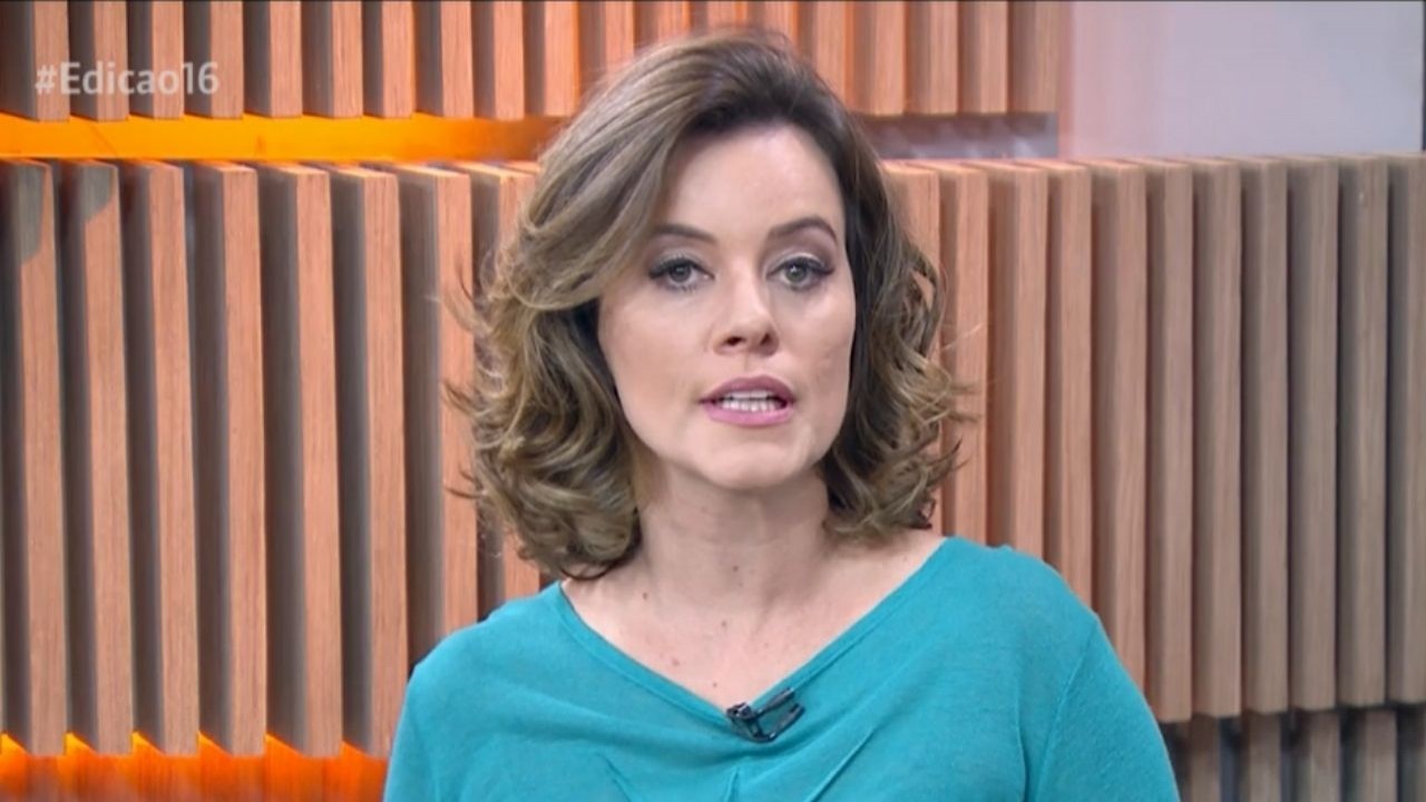 Natuza Nery de blusa verde no cenário da GloboNews falando para a câmera