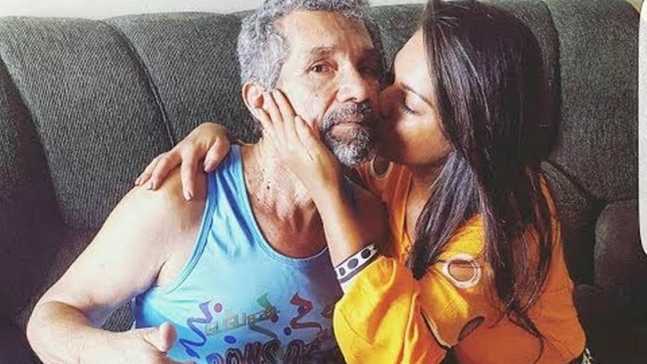 Paulinha Abelha dando beijo no pai no sofá