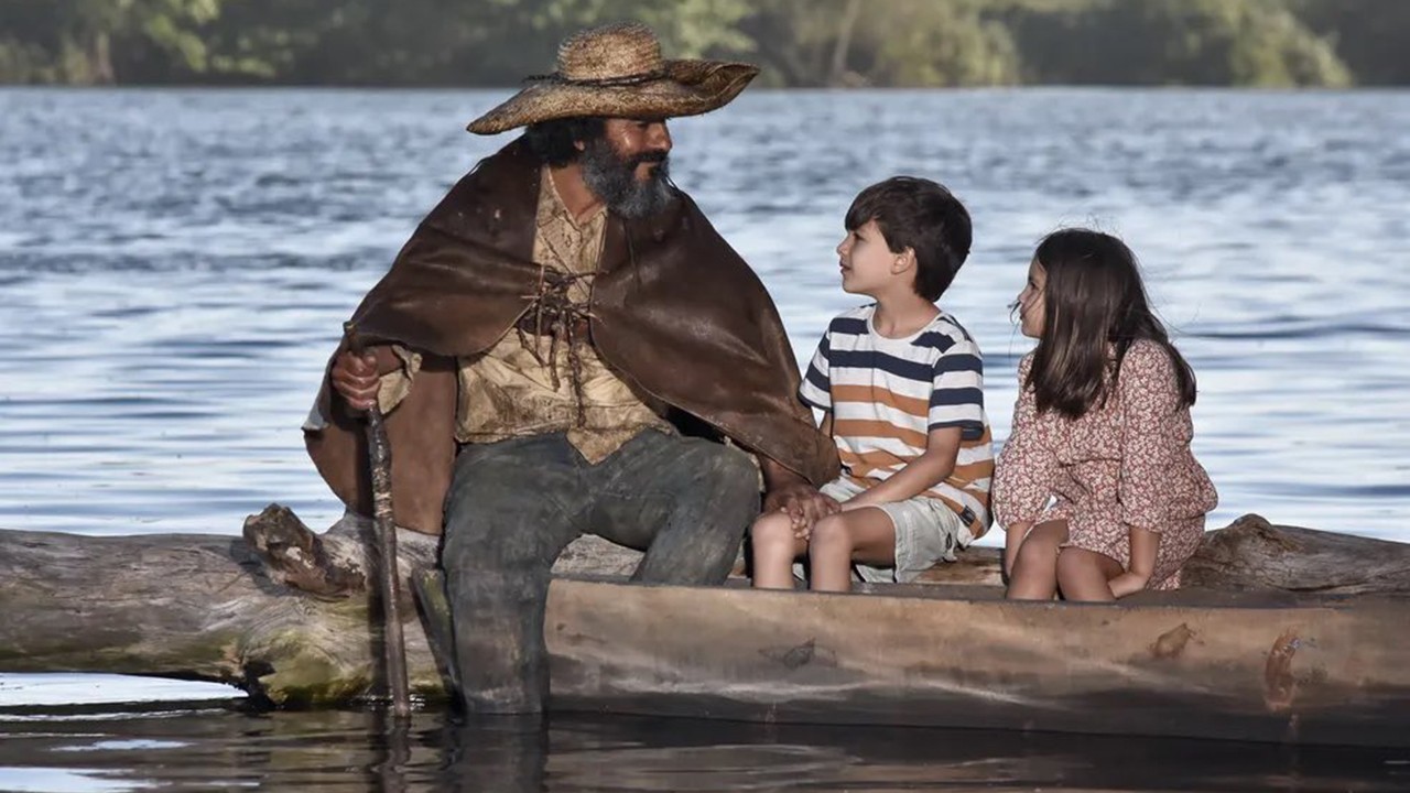 Cena do Velho do Rio conversando com duas crianças no barco