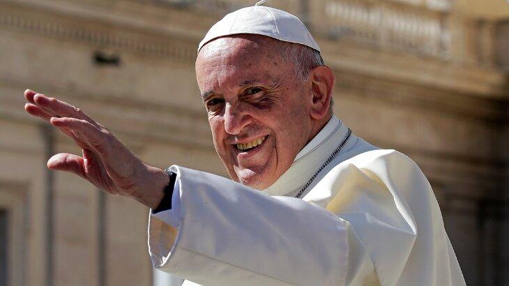 Papa Francisco sorrindo com a mão levantada