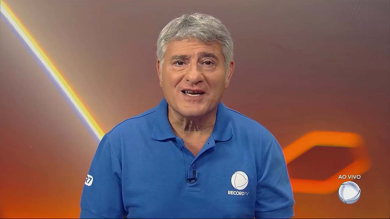 Cléber Machado usando camisa azul com o logotipo da Record no peito durante sua participação na final do Paulistão 2023