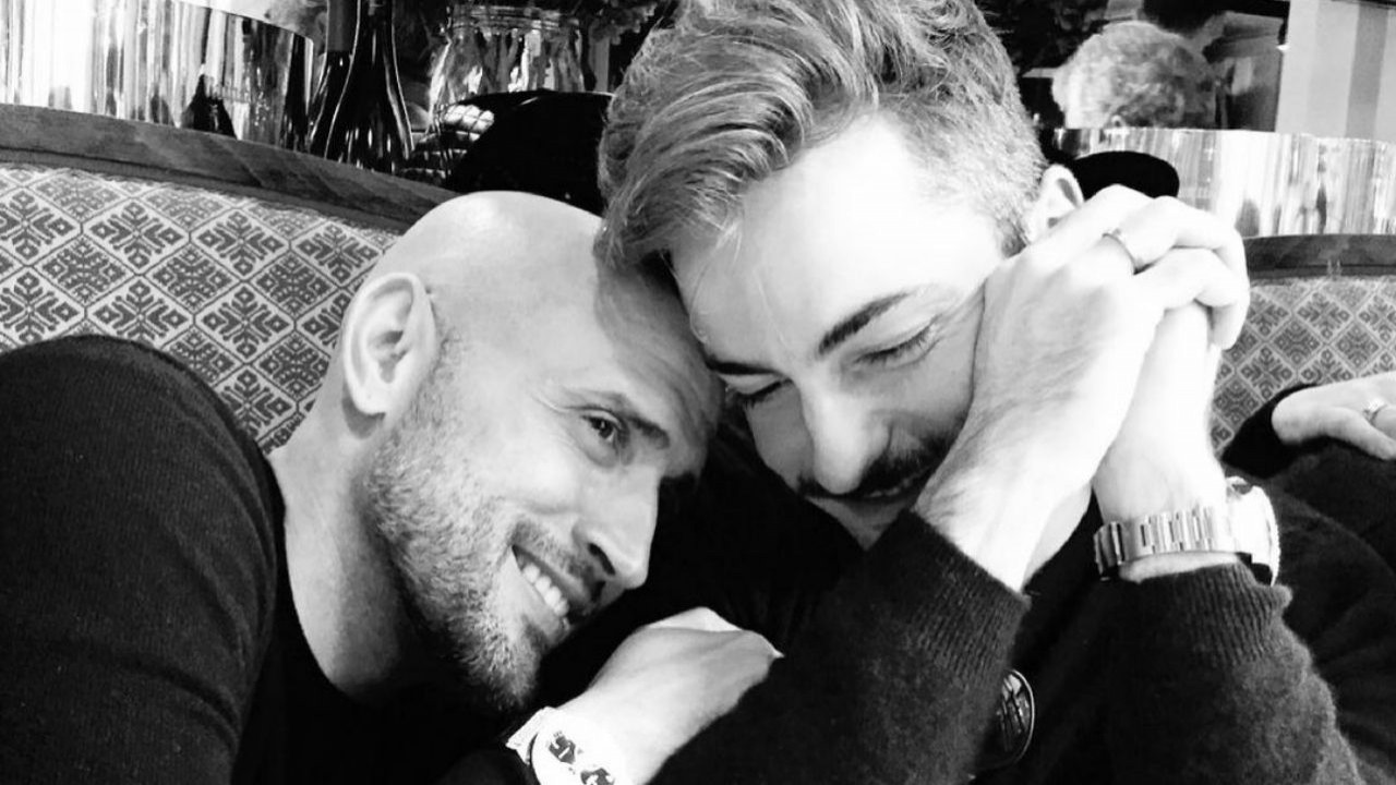 Paulo Gustavo e Thales Bretas abraçados e sorrindo; foto em preto e branco