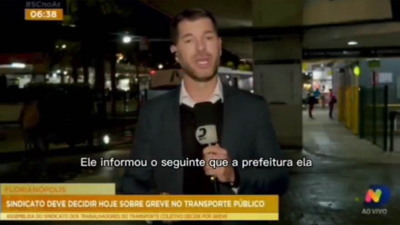 Repórter Paulo Mueller segurando microfone em terminal de transportes
