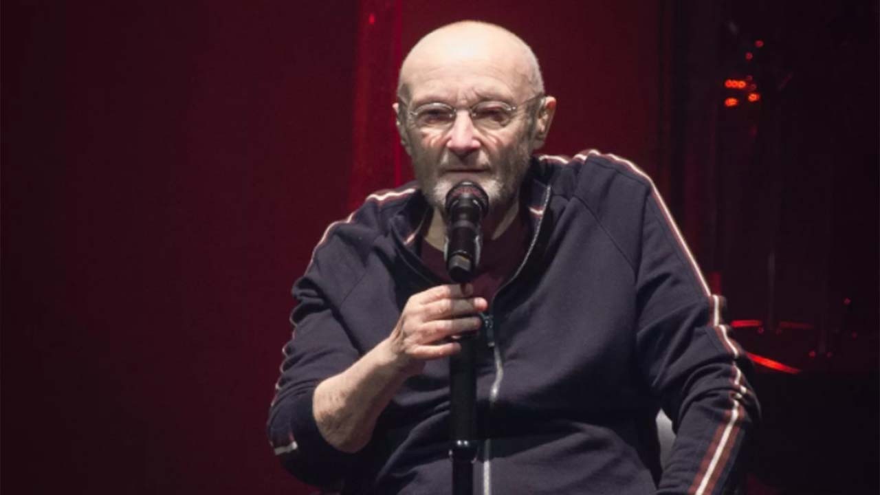 Phil Collins segurando microfone em show