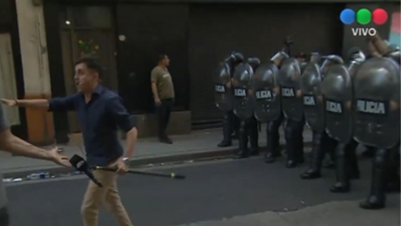 Heber Ybañez em frente à barreira policial, com microfone, caminhando