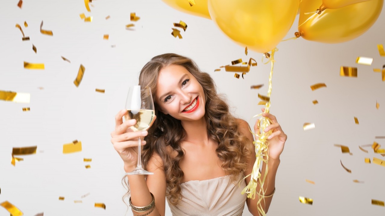 Mulher segurando uma taça de champanhe e bolas amarelas
