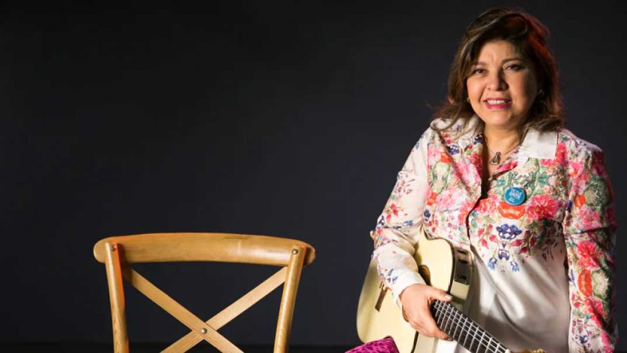 Roberta Miranda com violão na mão e cadeira ao lado