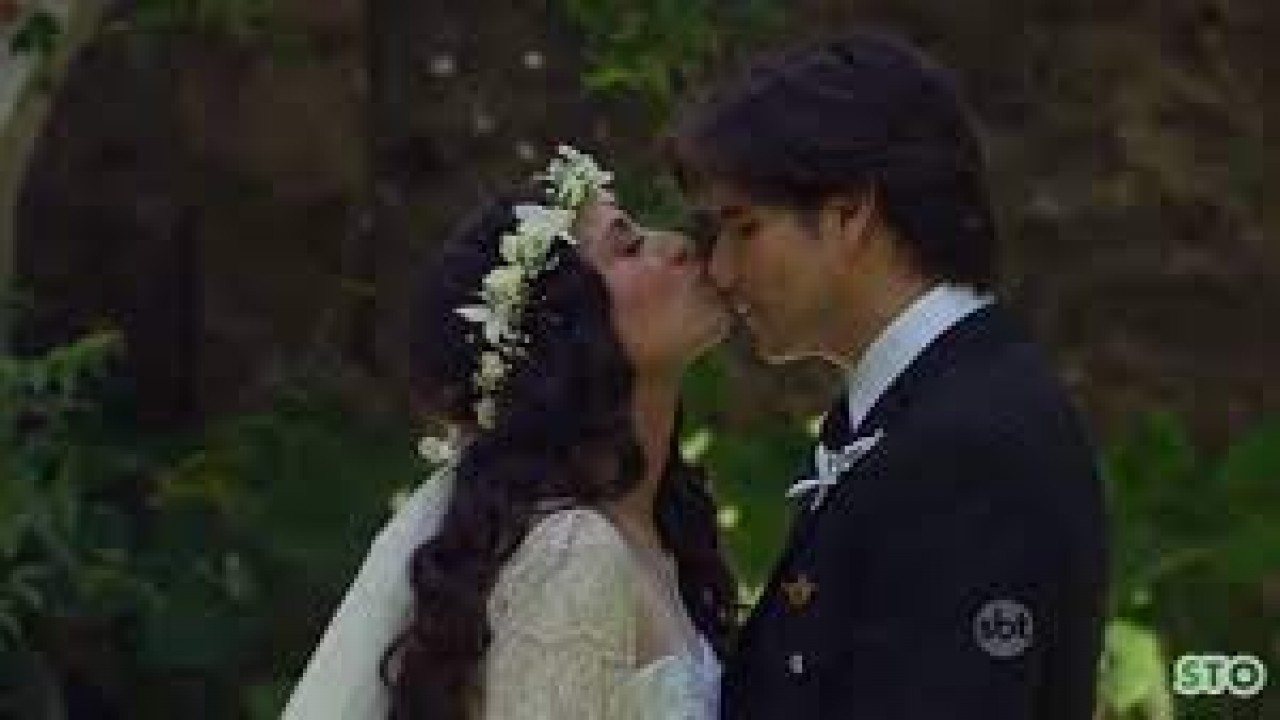 Cena de Coração Indomável com Maricruz e Otávio se beijando e vestidos de noivos