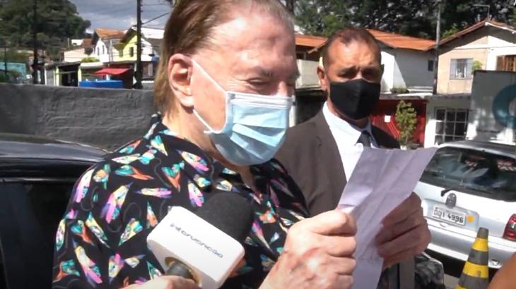 Silvio Santos lê carta, vestido de pijama, durante sua vacinação contra Covid-19