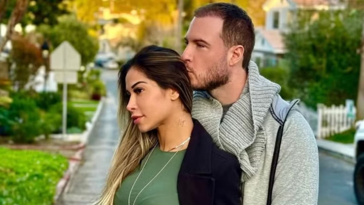 Maíra Cardi e Thiago Nigro abraçados, ela séria de perfil e ele beijando a cabeça dela