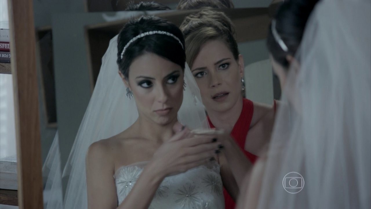 Cristina encarando Clara pelo reflexo no espelho, assustada