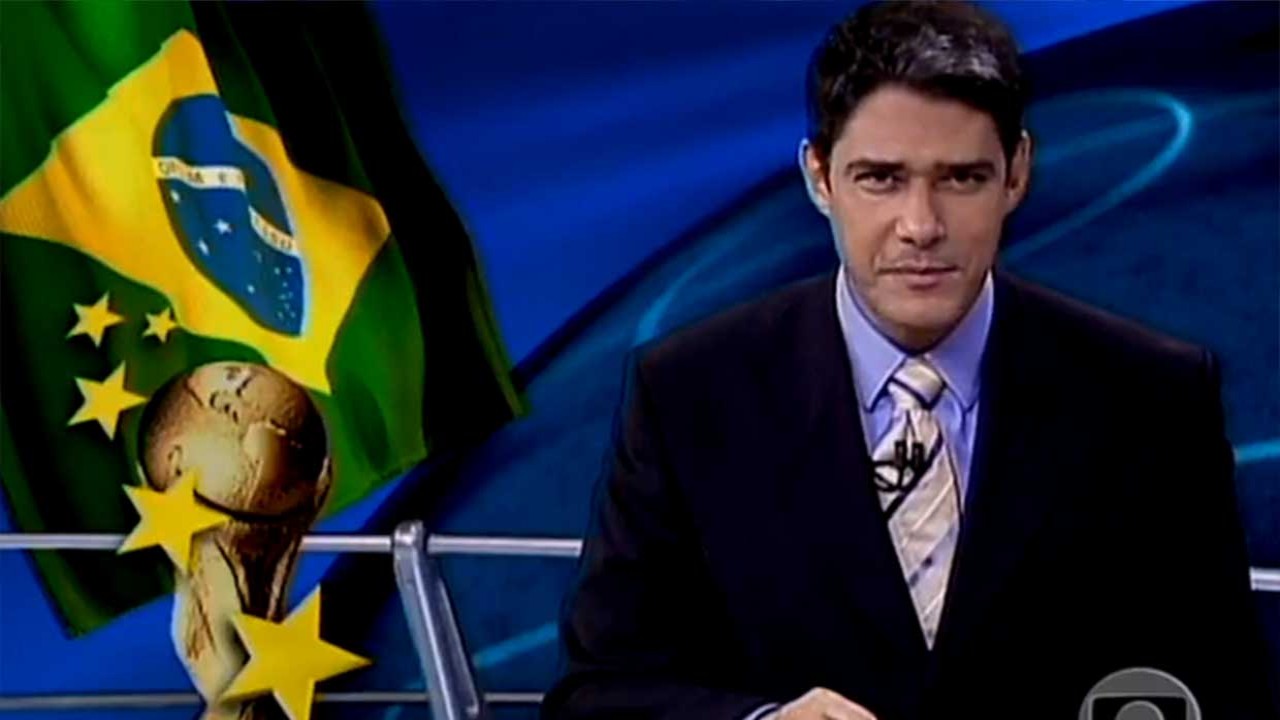 William Bonner na bancada do Jornal Nacional; com arte com bandeira do Brasil e taça