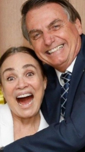 Regina Duarte sendo abraçada por Jair Bolsonaro, os dois com expressões alegres