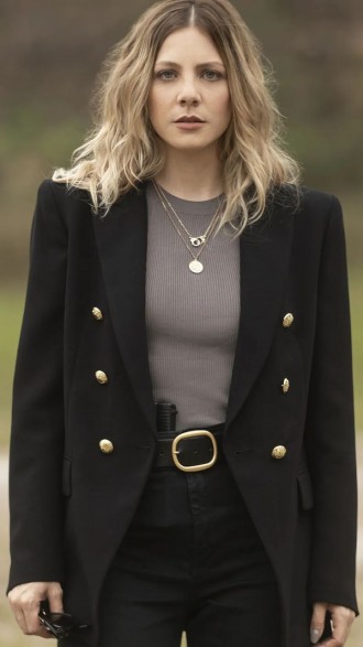 Elisa Volpatto posando para foto sem sorrir, de blusa cinza e blazer preto